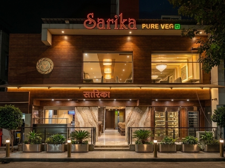 Hotel Sarika exterior at night — illuminated Sarika Pure Veg signage above the entrance